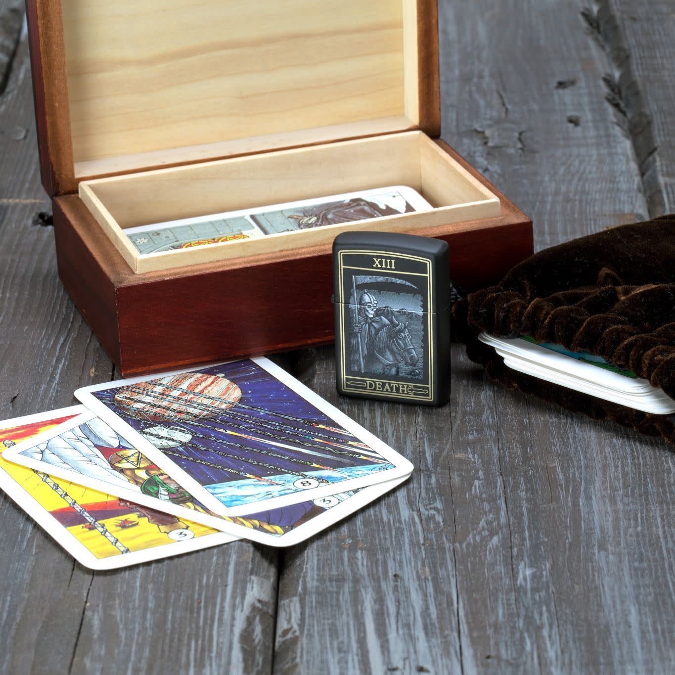 Front view of the Death Card Design Lighter standing next to tarot cards on a wooden background